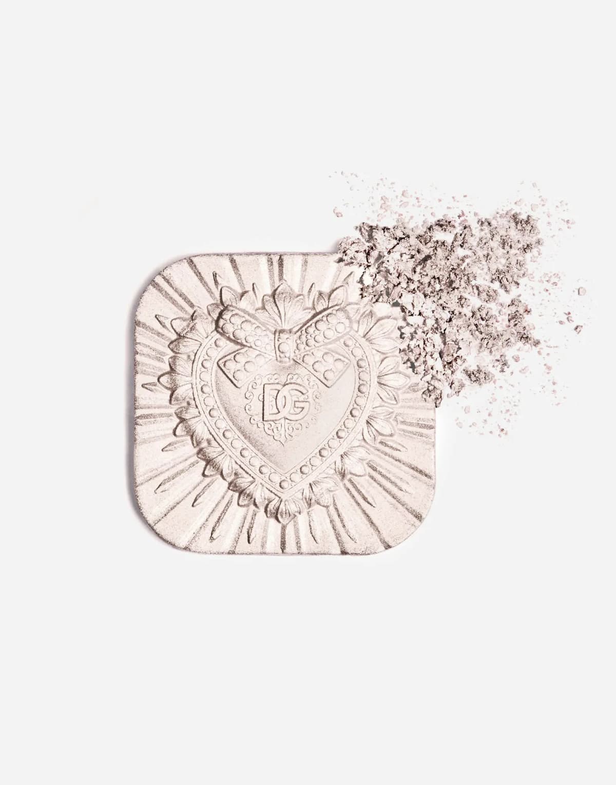 Unpackaged pale pink pearl highlighter pan beside a scatter of crushed shimmering powder