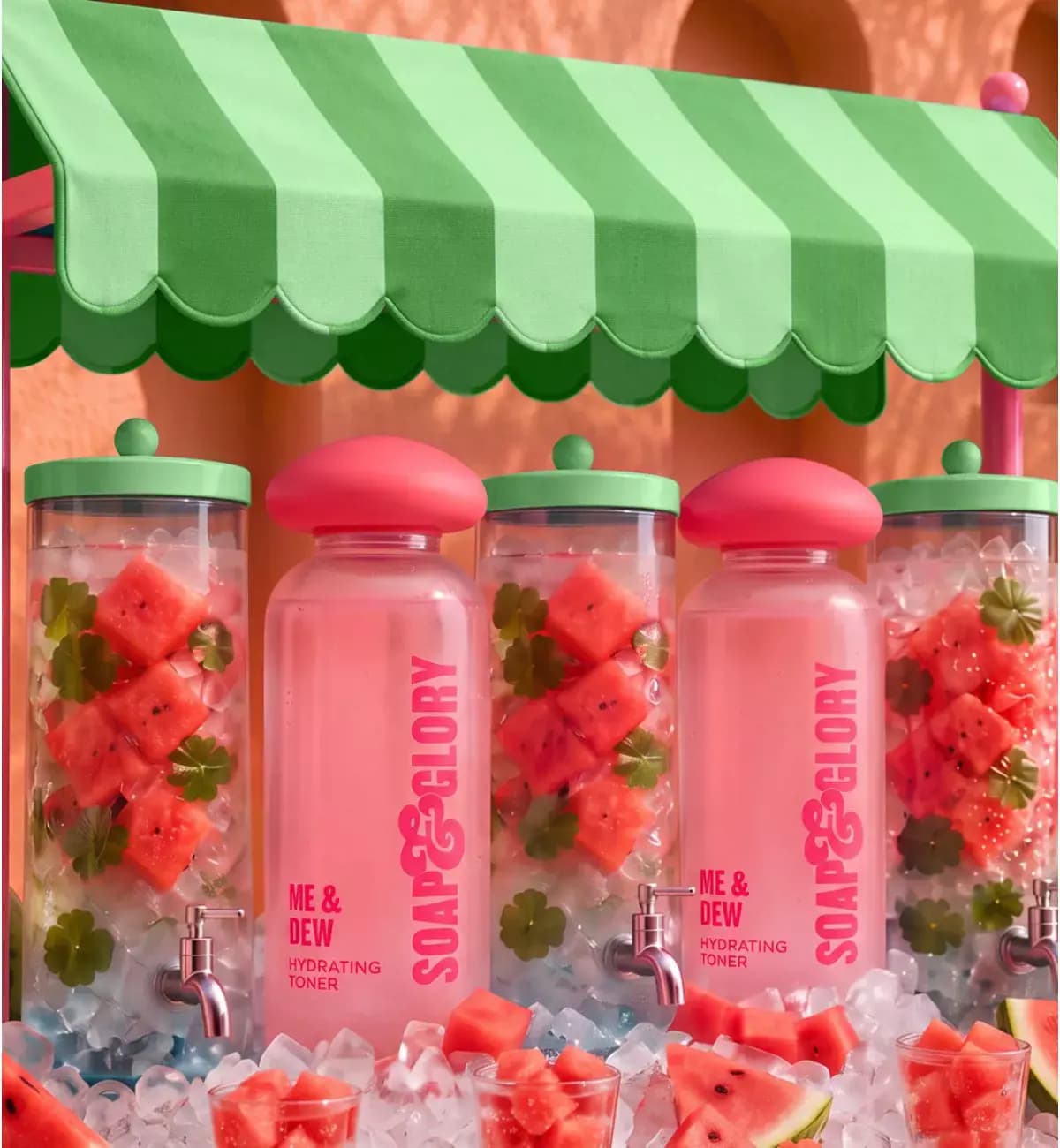Pink Me & Dew Hydrating Toner bottles between watermelon-filled drink dispensers under a green striped awning