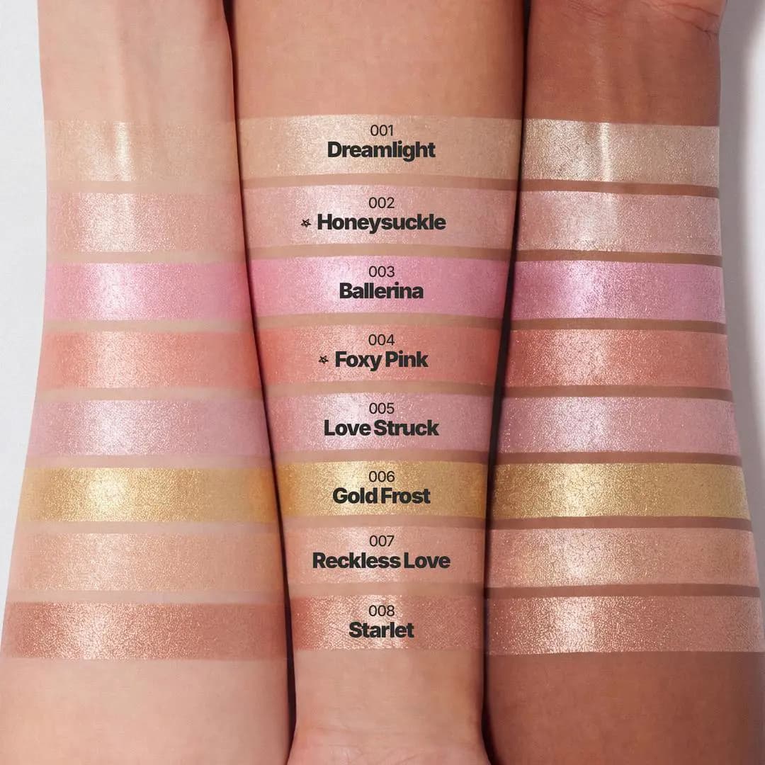 Three arms of varying skin tones swatched with eight shimmery highlighter shades including Dreamlight, Honeysuckle