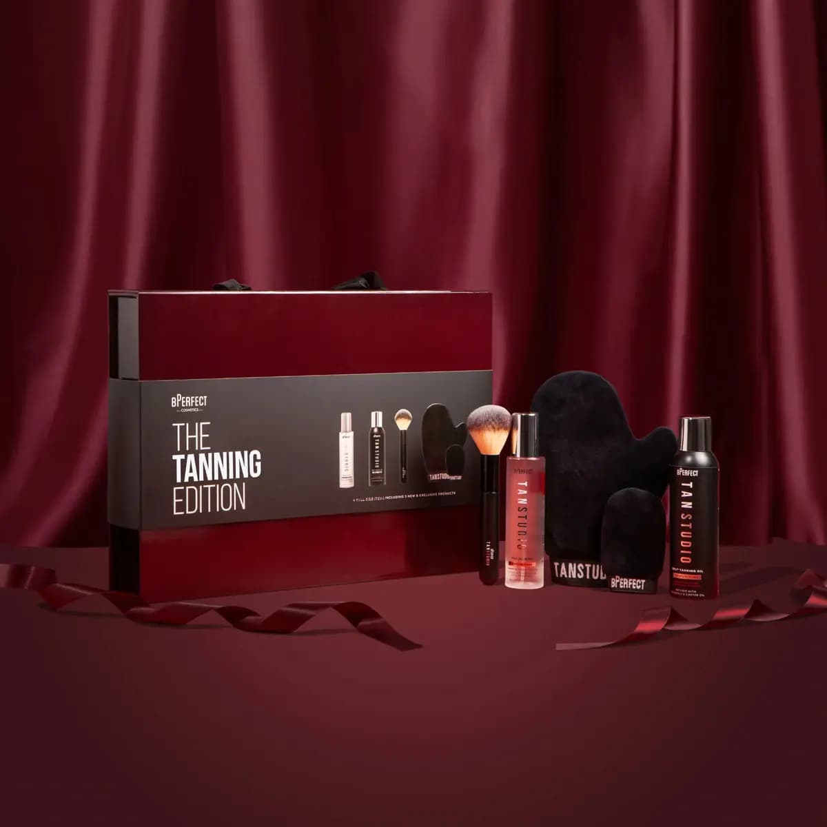 BPerfect The Tanning Edition box with Tan Studio facial mist, tanning oil, kabuki brush and black velvet mitts
