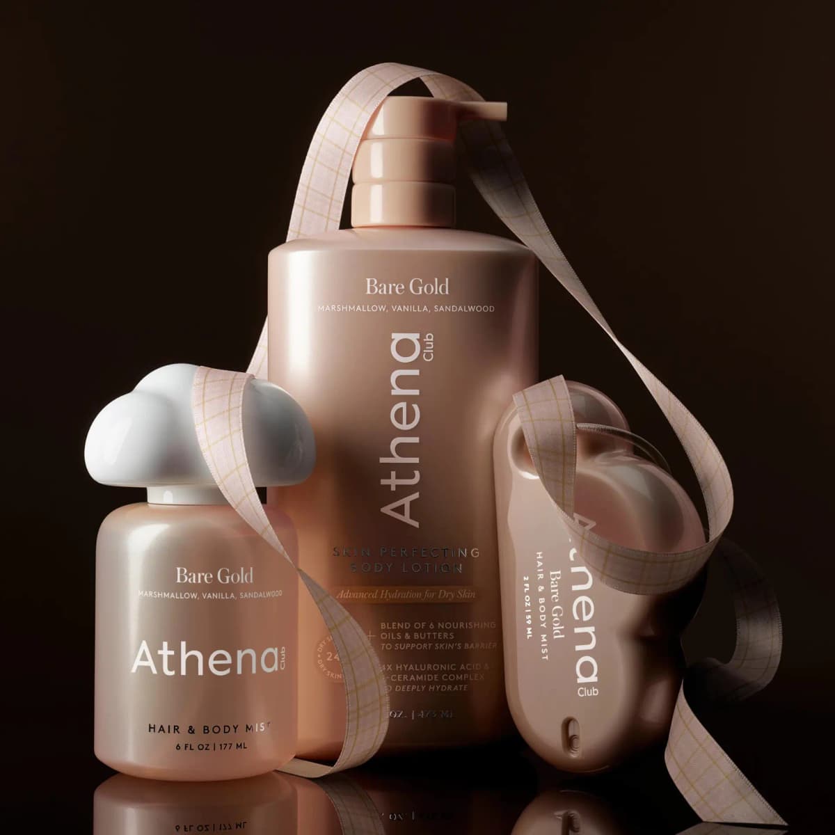 Lotion, cloud-capped mist and cloud-shaped mini mist wrapped in plaid ribbon against a dark brown background
