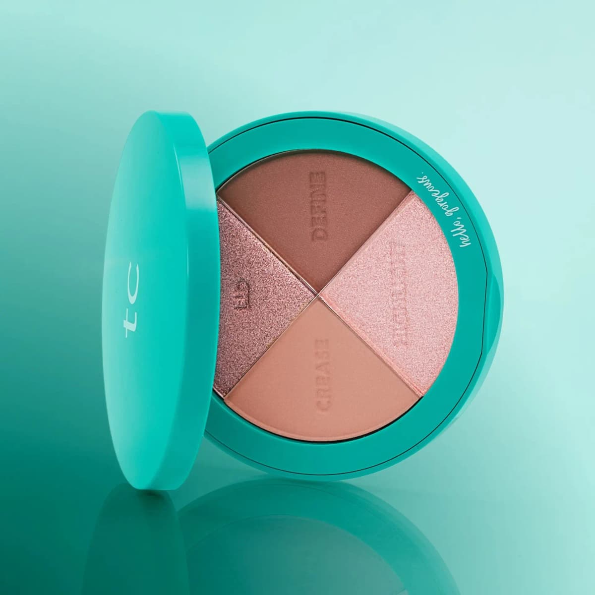Classic Pinks palette tilted beside its open teal lid on a glossy mint surface, showing four pink and brown pans.