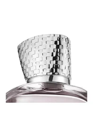 Close-up of the polished silver cap with a raised checkerboard texture above the bottle's shoulder