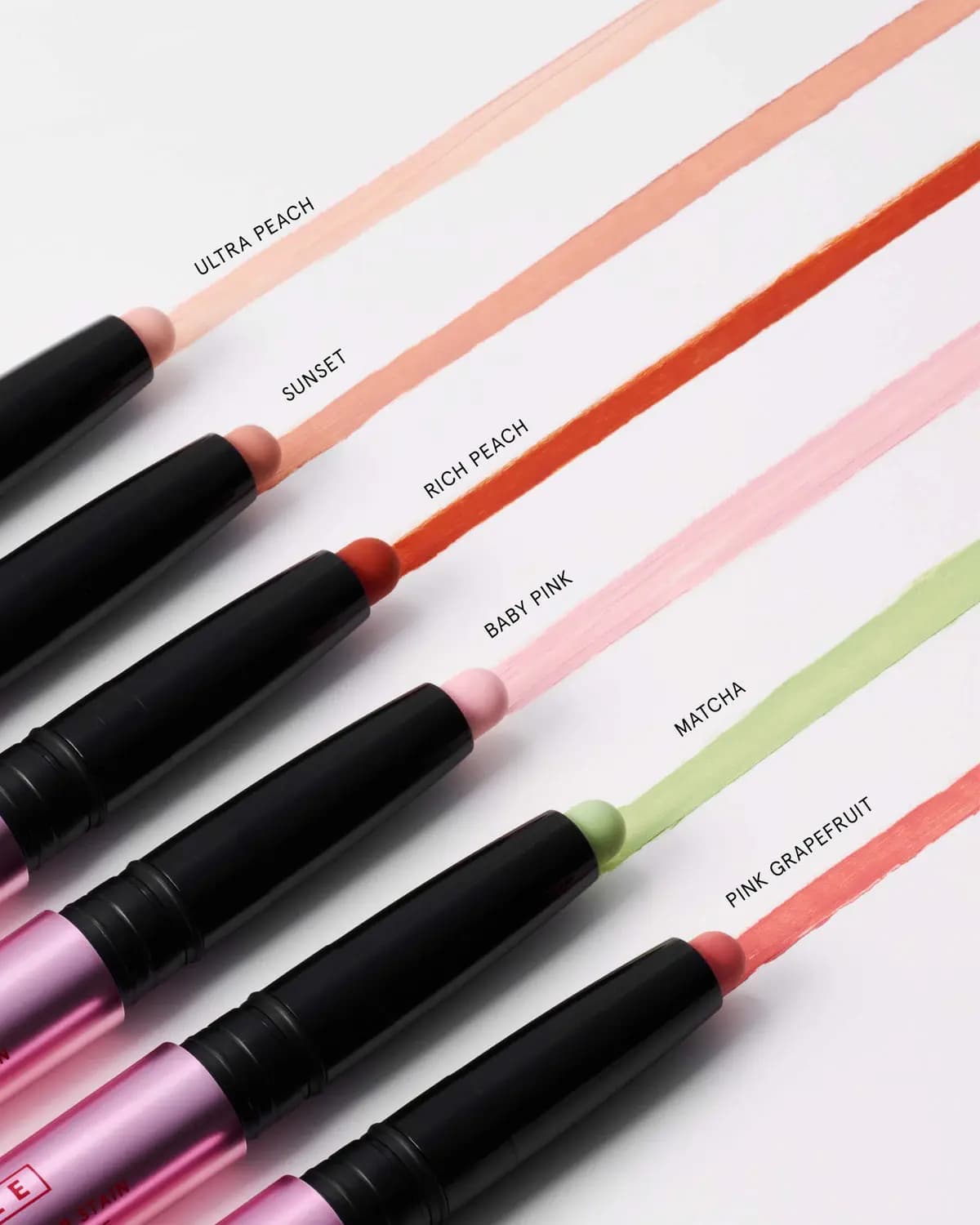 Angled row of stain sticks drawing labelled lines in Ultra Peach, Sunset, Rich Peach, Baby Pink, Matcha and Pink Grapefruit