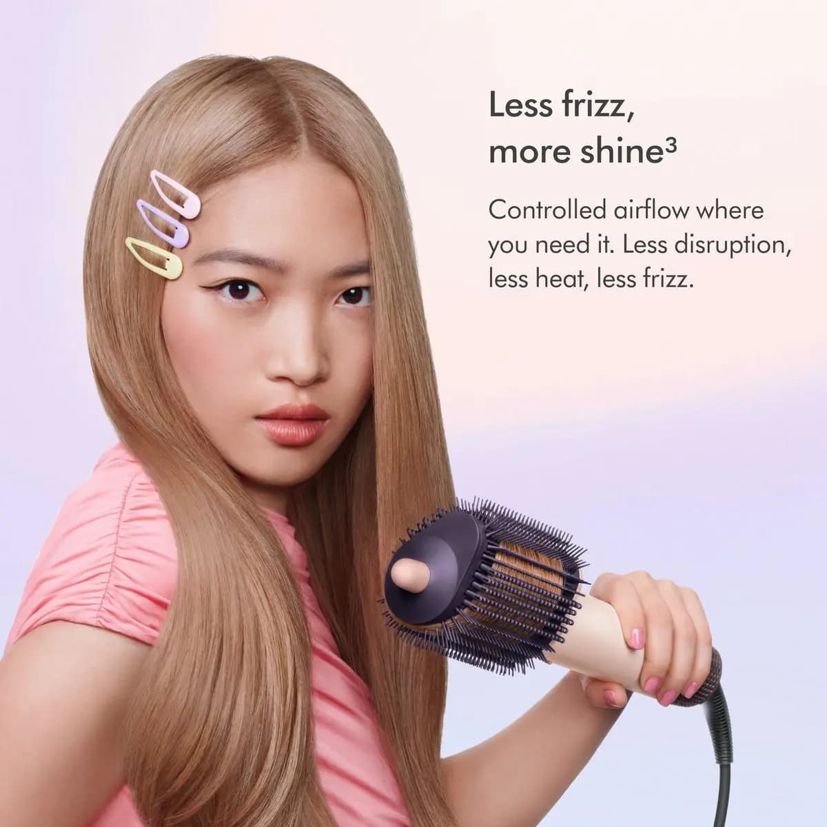 Model with long straight hair and pastel clips holds the brush beside text about less frizz and more shine
