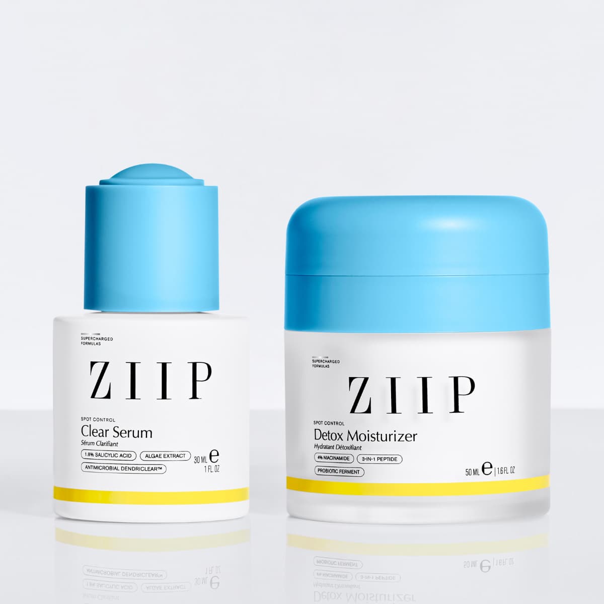 Clear Serum and Detox Moisturizer duo with matching blue caps on a glossy white surface