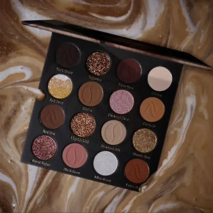 Open Arttitude Espresso palette of 16 brown, cream and gold mattes and glitters on a swirled coffee-and-milk backdrop