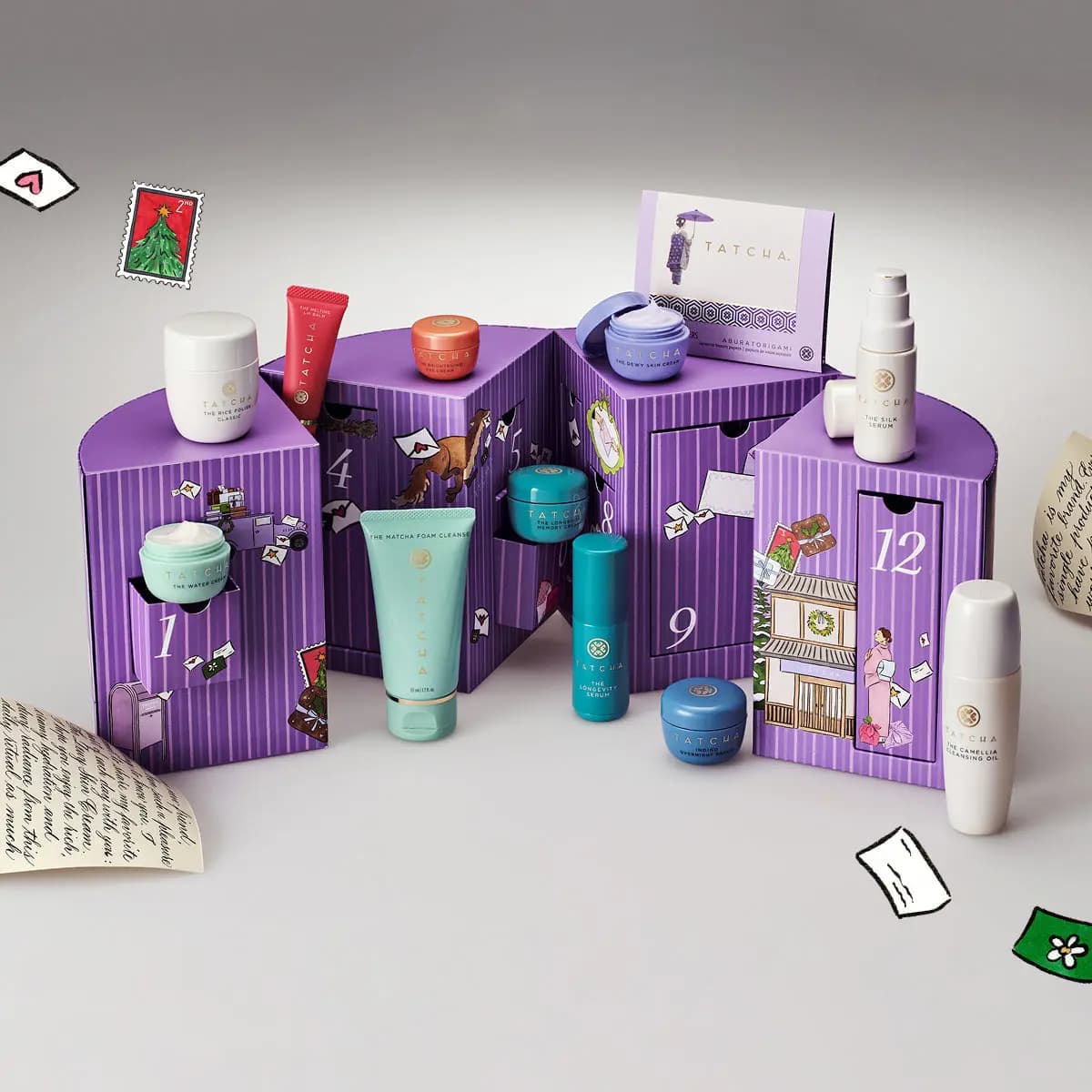 Purple striped numbered Tatcha box opened with minis like The Water Cream, The Silk Serum and The Camellia Cleansing Oil