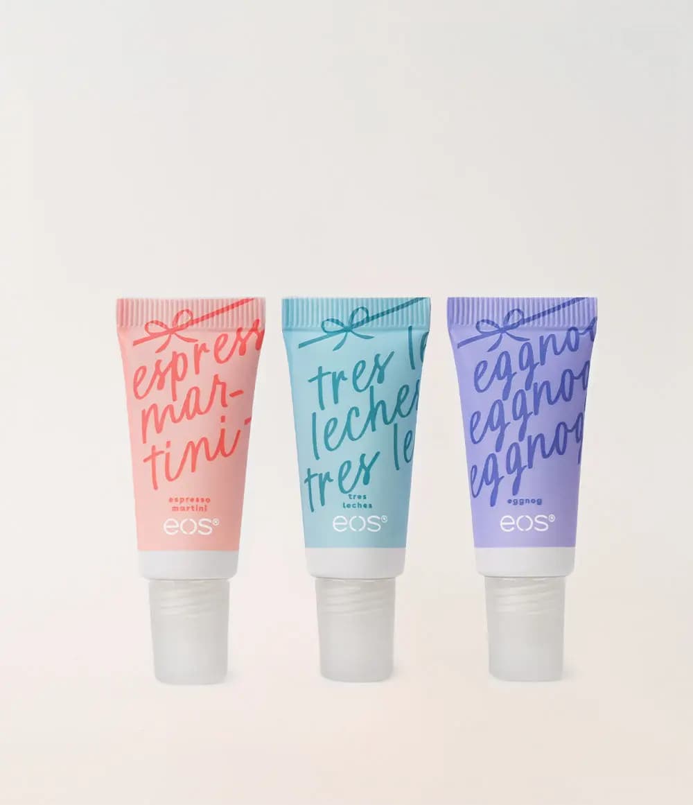 Peach, aqua and lavender eos mini balm tubes with script flavor names and frosted caps lined up on a plain cream backdrop