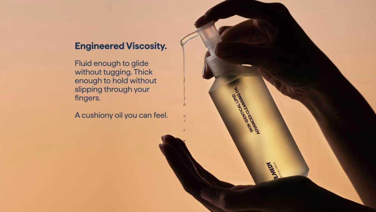 Backlit hands dispensing slow drips of oil beside text about engineered viscosity and a cushiony feel