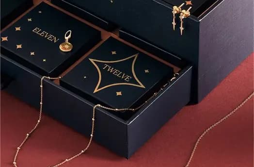 Close-up of numbered drawer compartments labelled Eleven and Twelve with gold charms and delicate chains