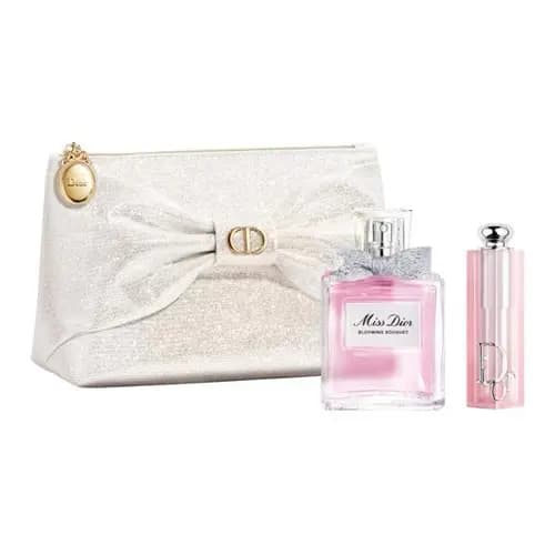 Ivory glitter bow pouch with gold medallion alongside a pink floral perfume bottle and pink lipstick tube