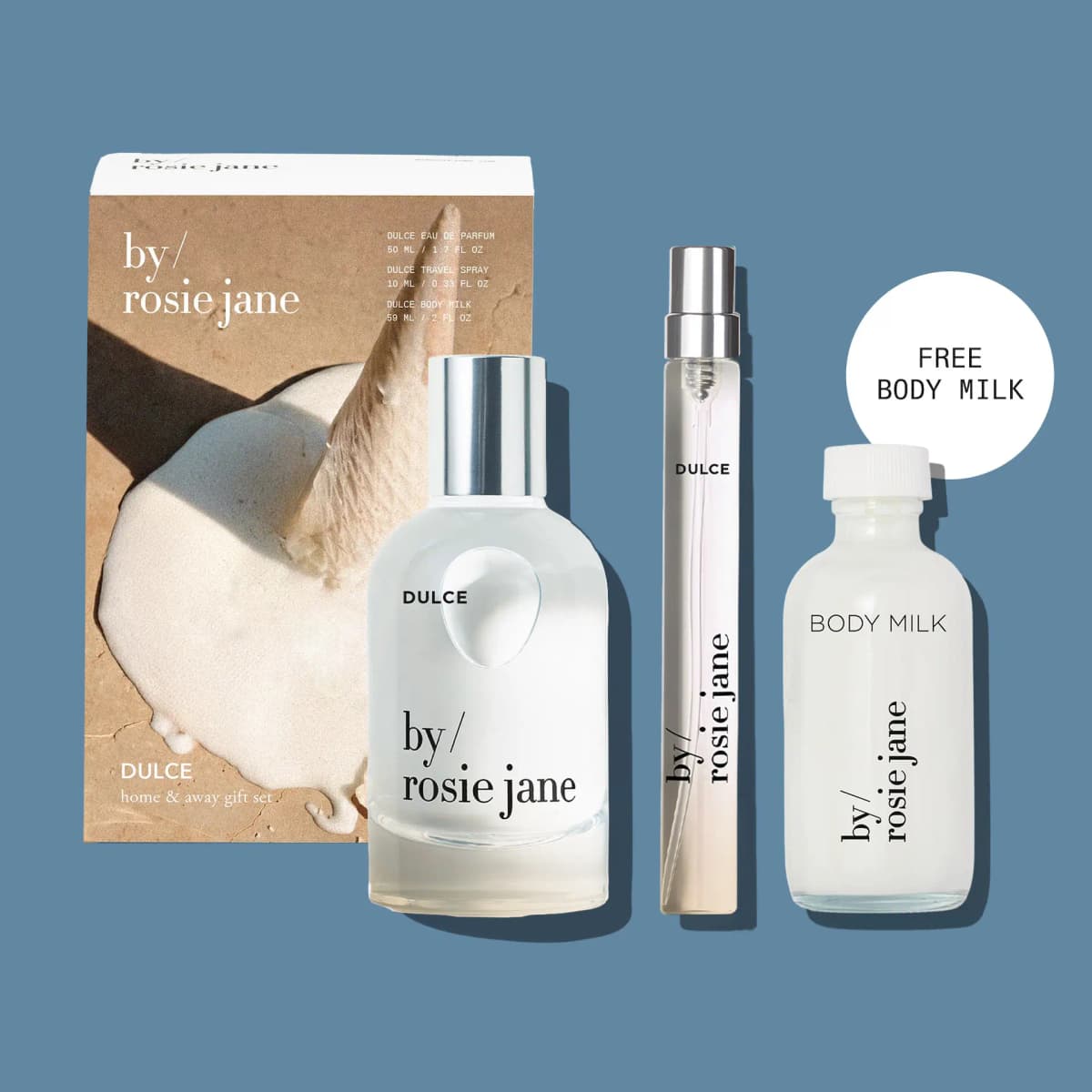 Dulce home & away gift set box with eau de parfum, travel spray and Free Body Milk bottle on a blue background