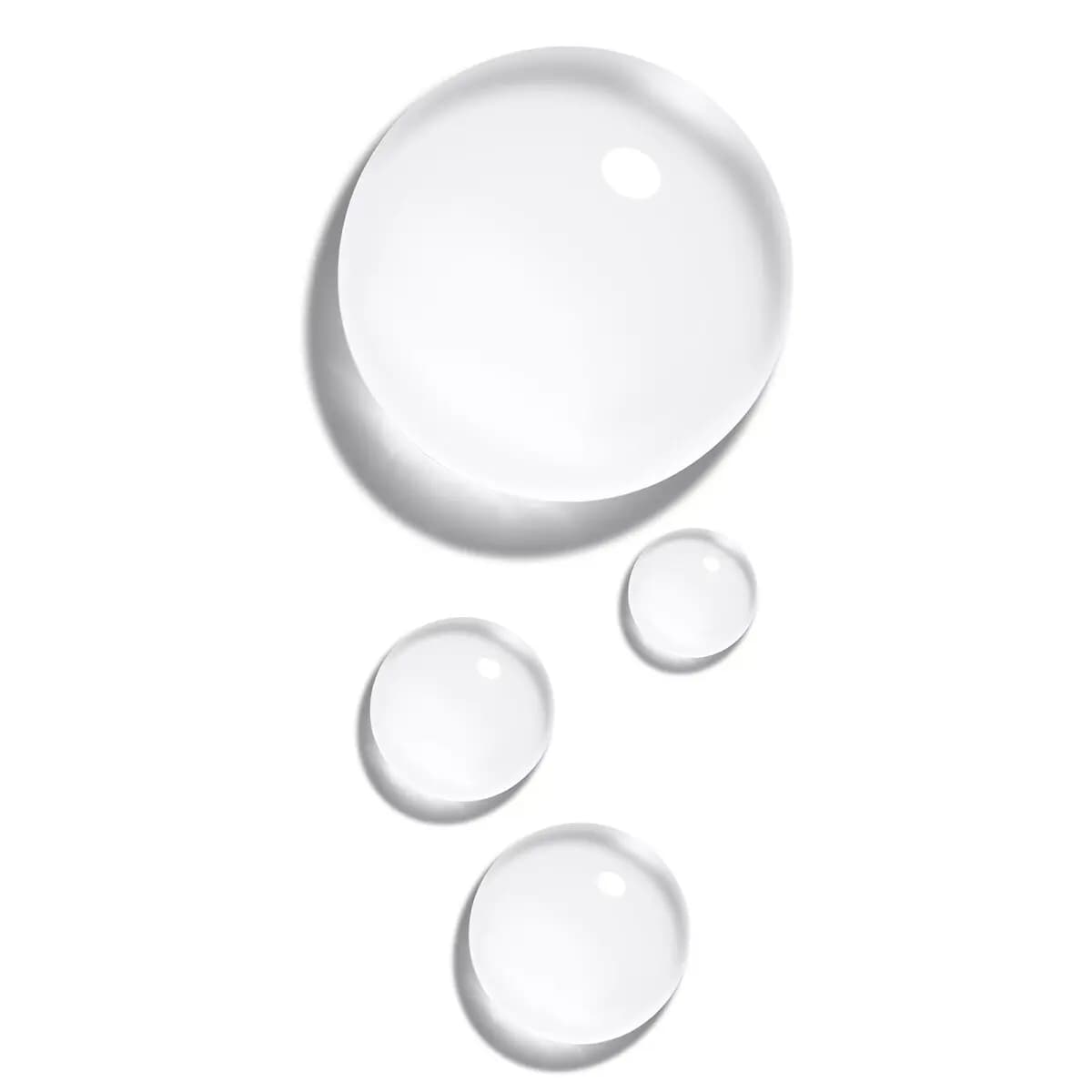 Clear, glossy droplets of the lotion texture in one large and three small beads on a white background.