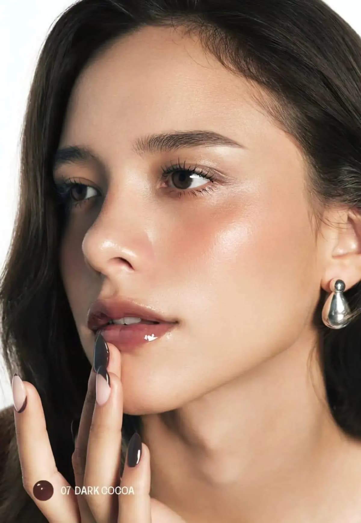 Dark-haired model with glossy brown-rose lips and brown nails, labelled 07 Dark Cocoa