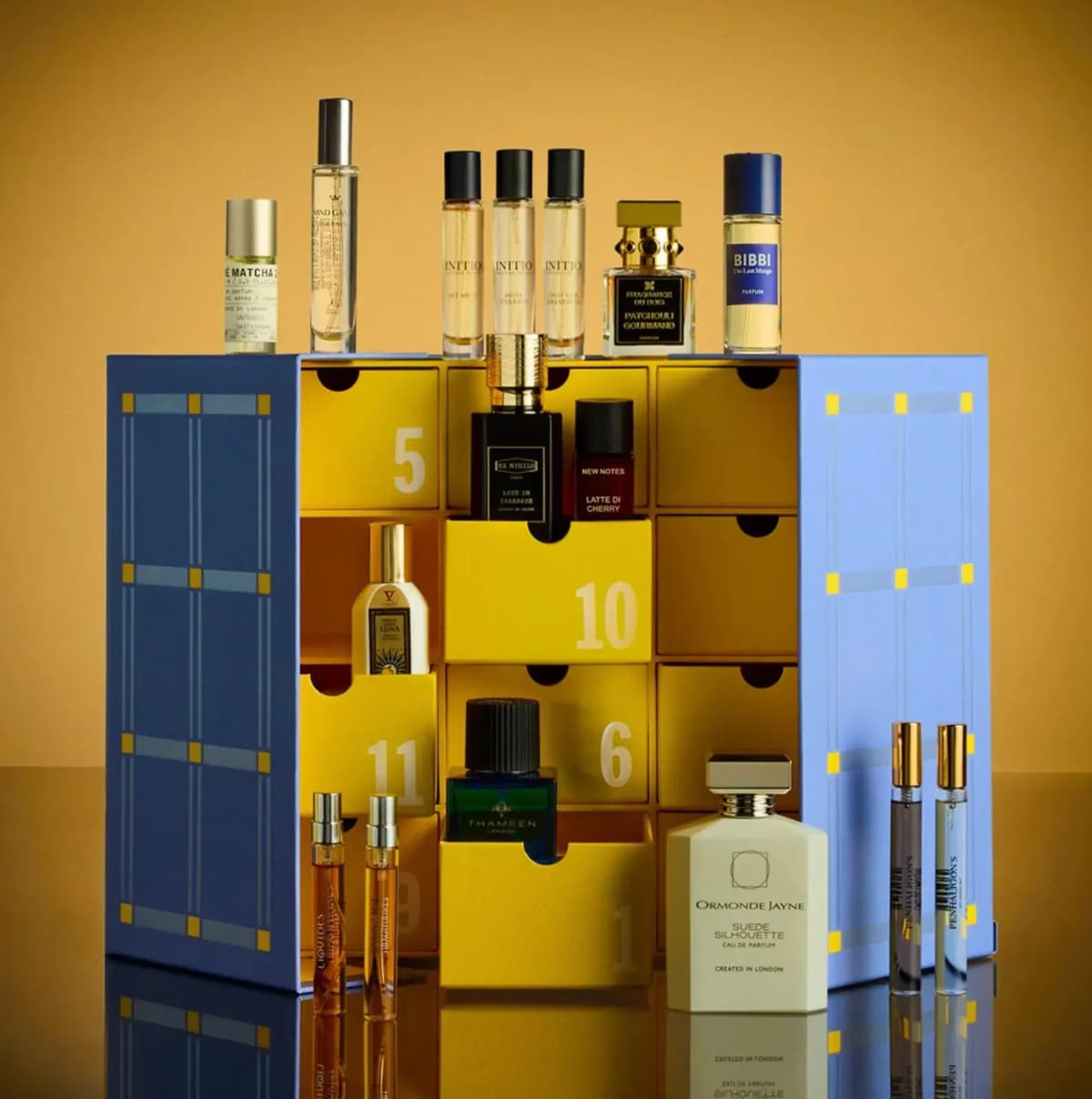 Selfridges Fragrance Advent Calendar 2026 open on yellow drawers with perfume bottles on top and around it, amber backdrop