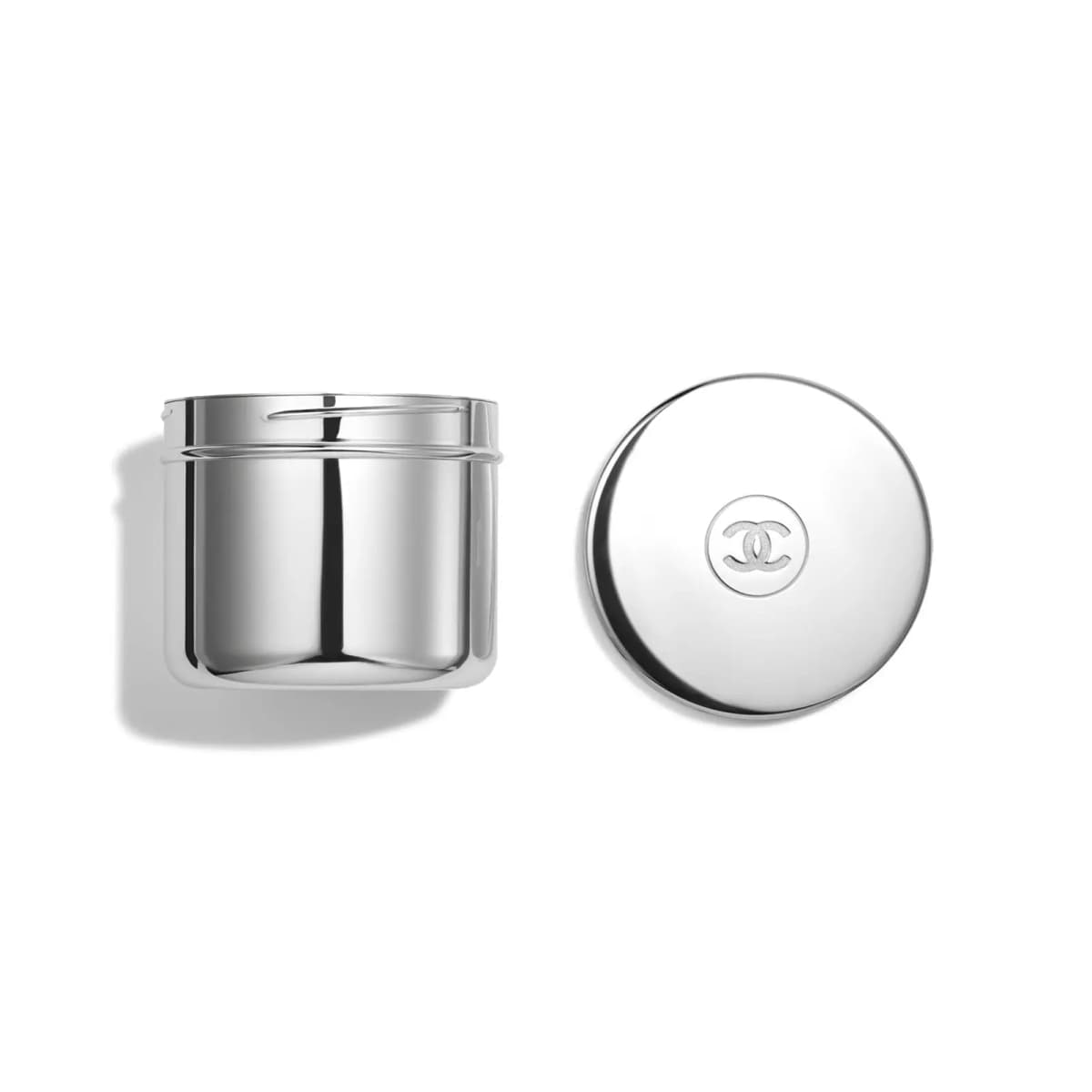 Shiny silver Éclat Premier refill pod beside its round mirrored lid stamped with a CC logo