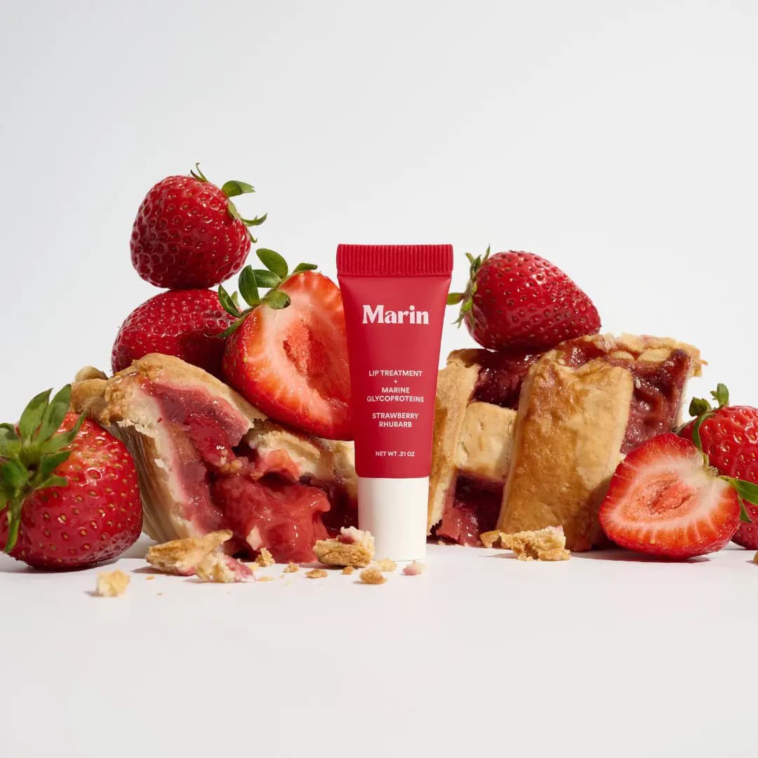 Red Strawberry Rhubarb tube between fresh strawberries and slices of lattice pie