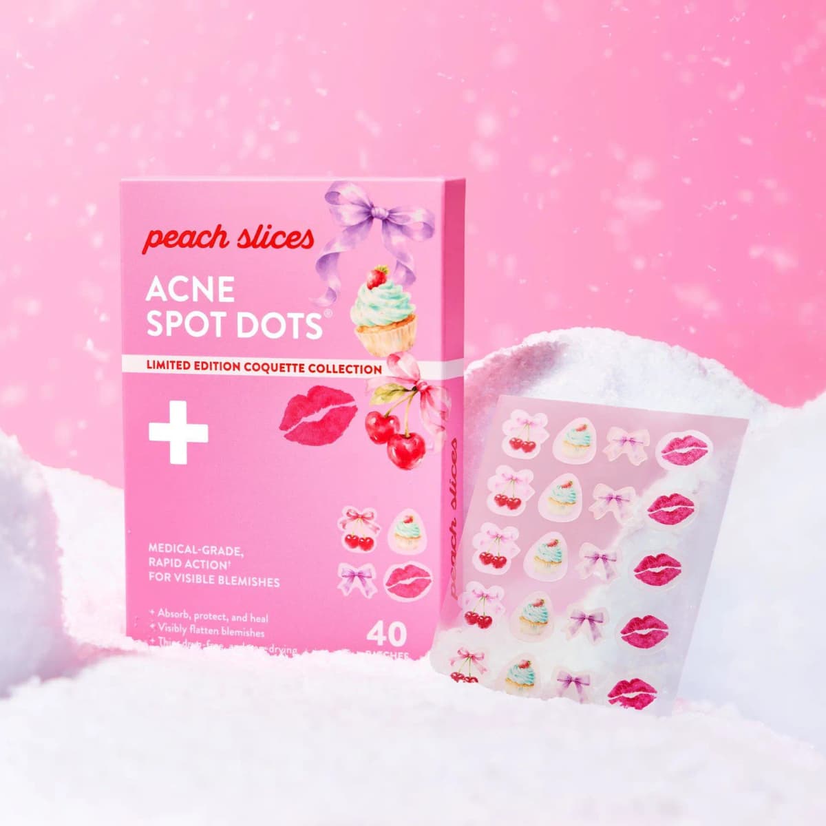 Acne Spot Dots Coquette box and patch sheet nestled in white snow against a pink, snow-speckled background