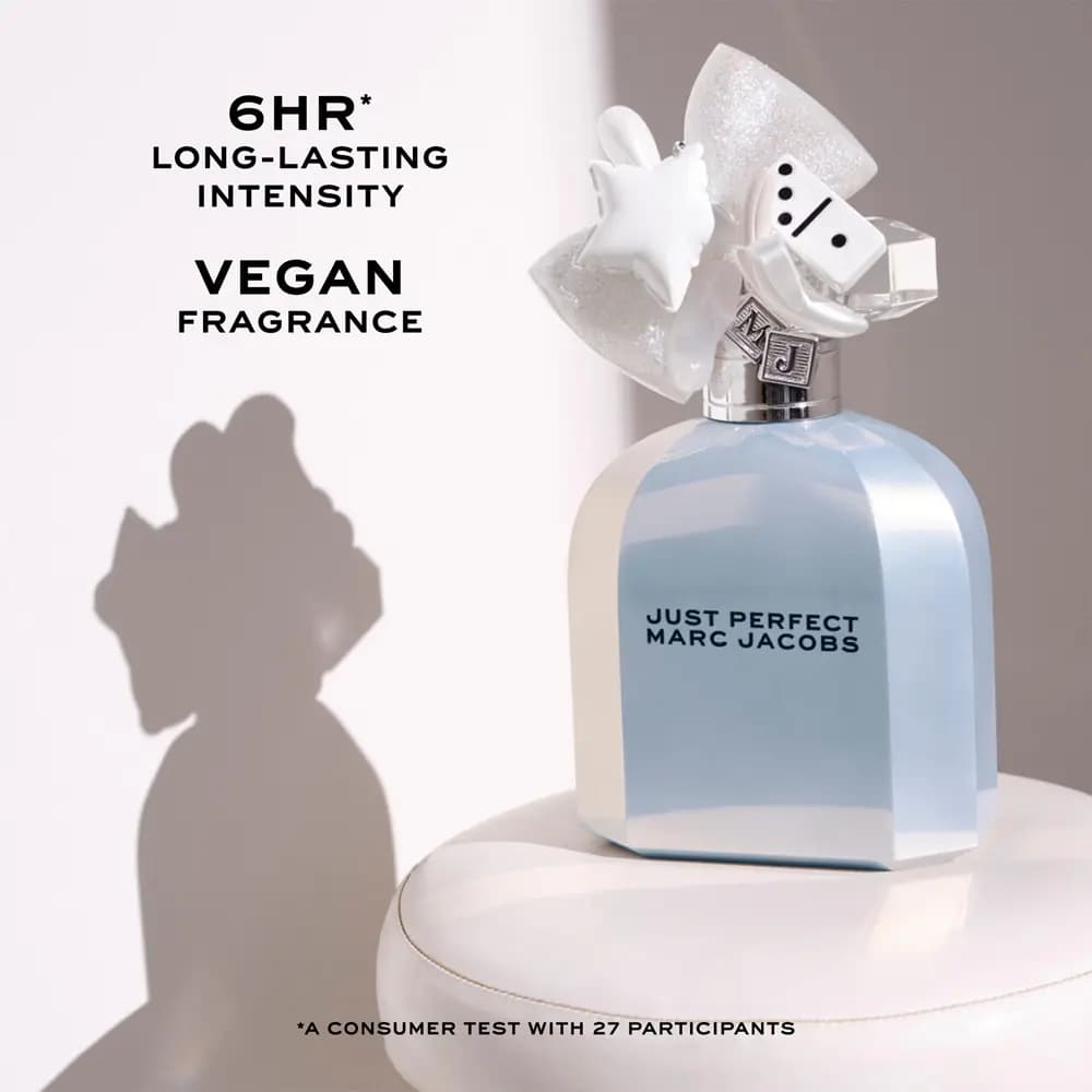 Just Perfect bottle on a white cushioned stool with text claiming 6-hour longevity and vegan fragrance