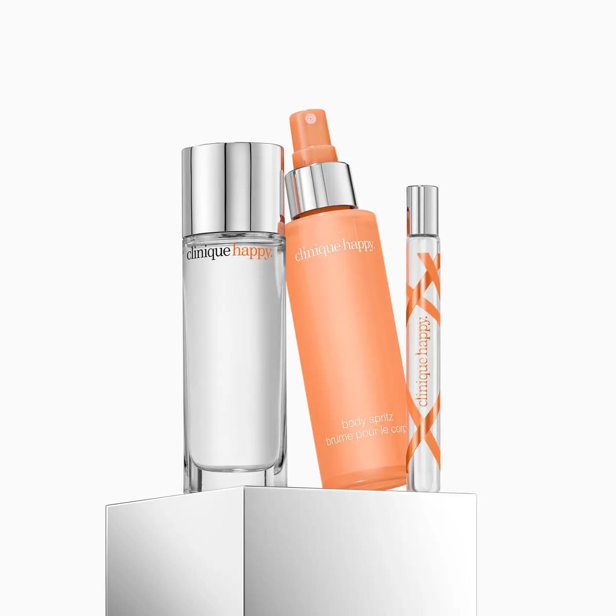 Clinique Happy perfume bottle, orange body spritz and slim travel spray