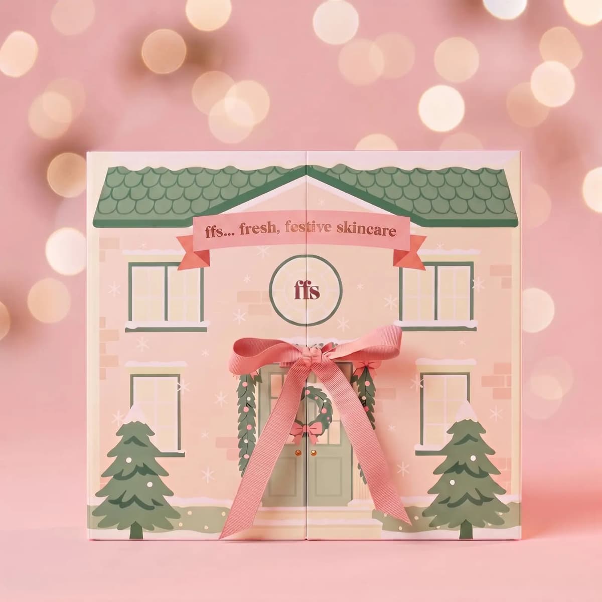 Closed FFS house-shaped advent calendar with green roof, pink ribbon bow and 'fresh, festive skincare' banner
