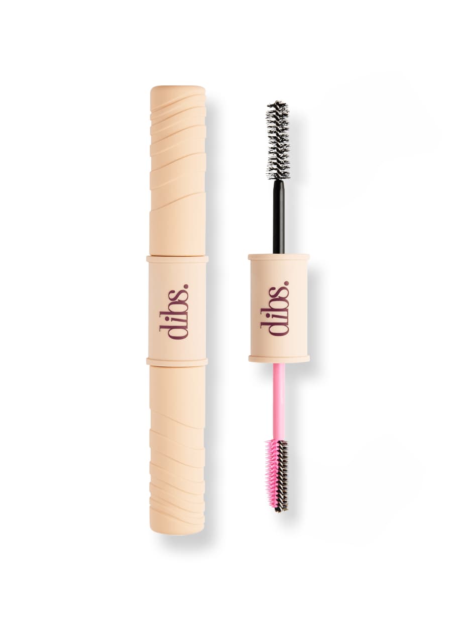 Closed beige dual-ended dibs. tube beside the open wand showing a black brush and a pink-handled brush