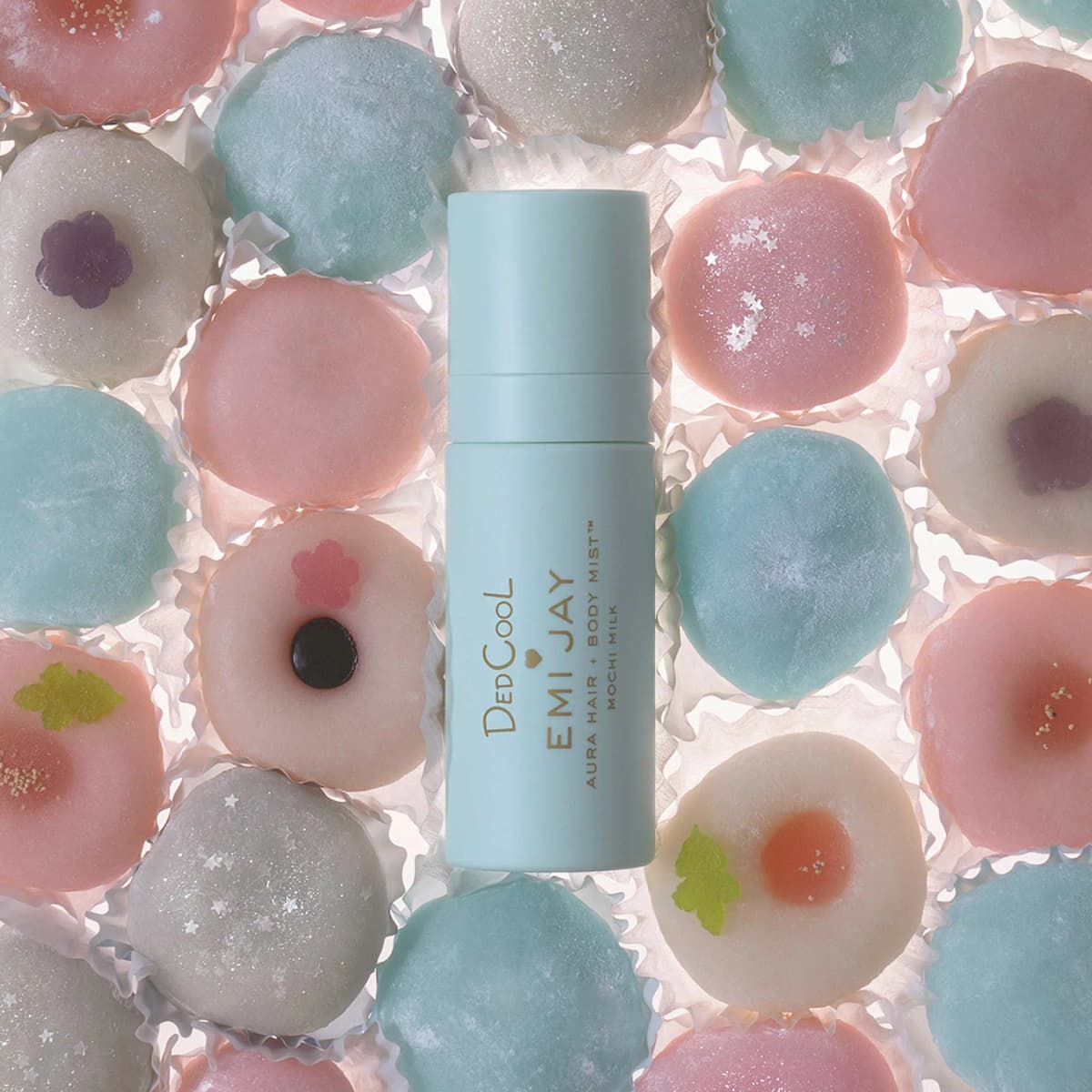 Capped mint mist bottle laid over rows of pink, blue and white mochi in paper cups