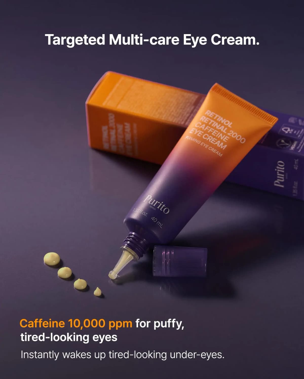 Purito eye cream tube tilted beside its orange box on a dark surface with four yellow cream droplets dispensed.