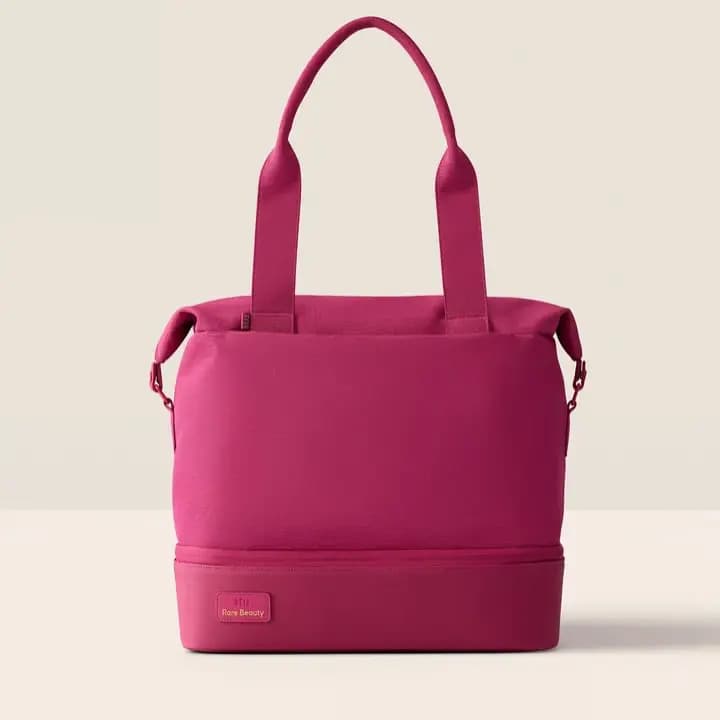 Raspberry canvas tote with shoulder straps and a zippered bottom compartment with Rare Beauty patch