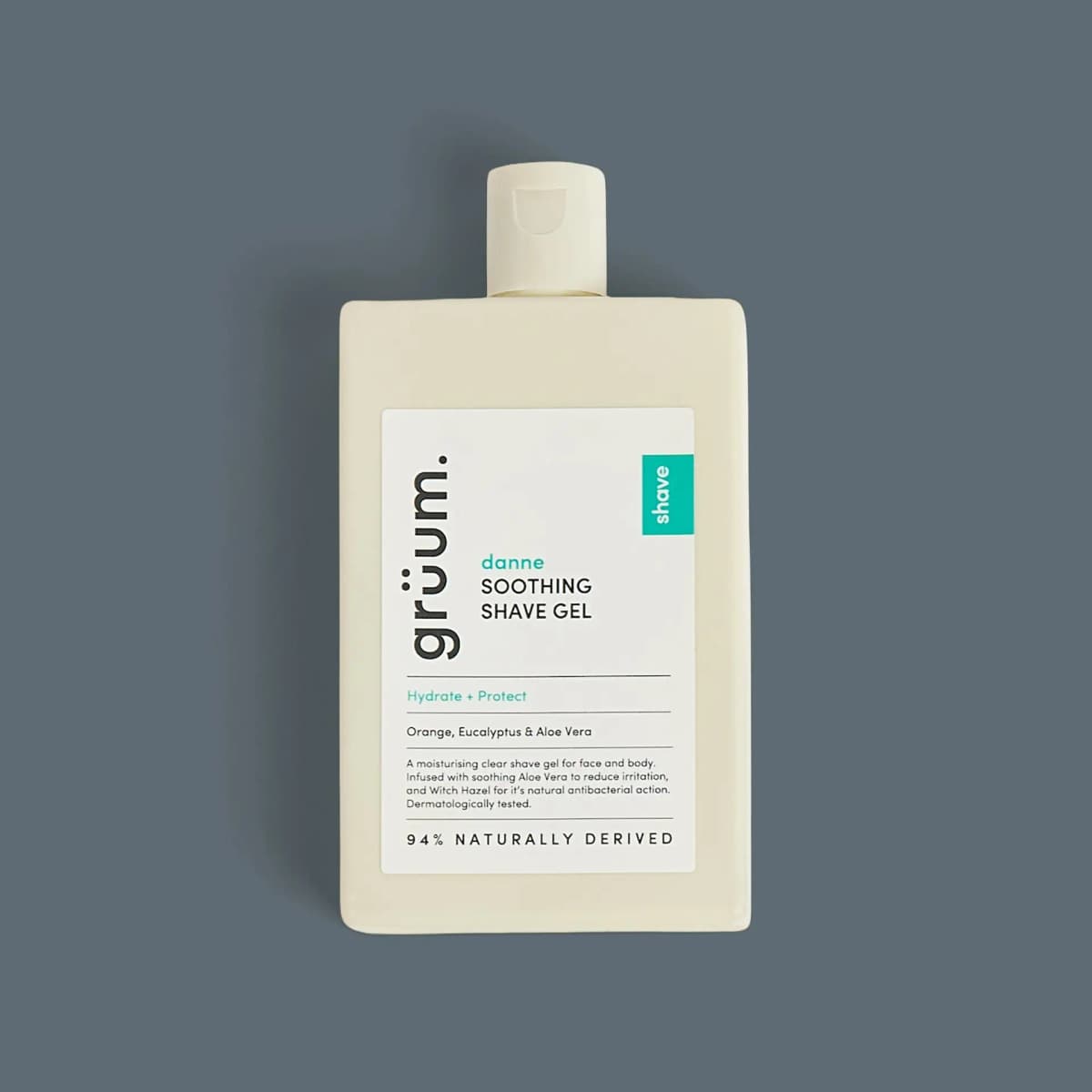 Cream grüum danne Soothing Shave Gel bottle with white label and teal 'shave' tab on slate grey