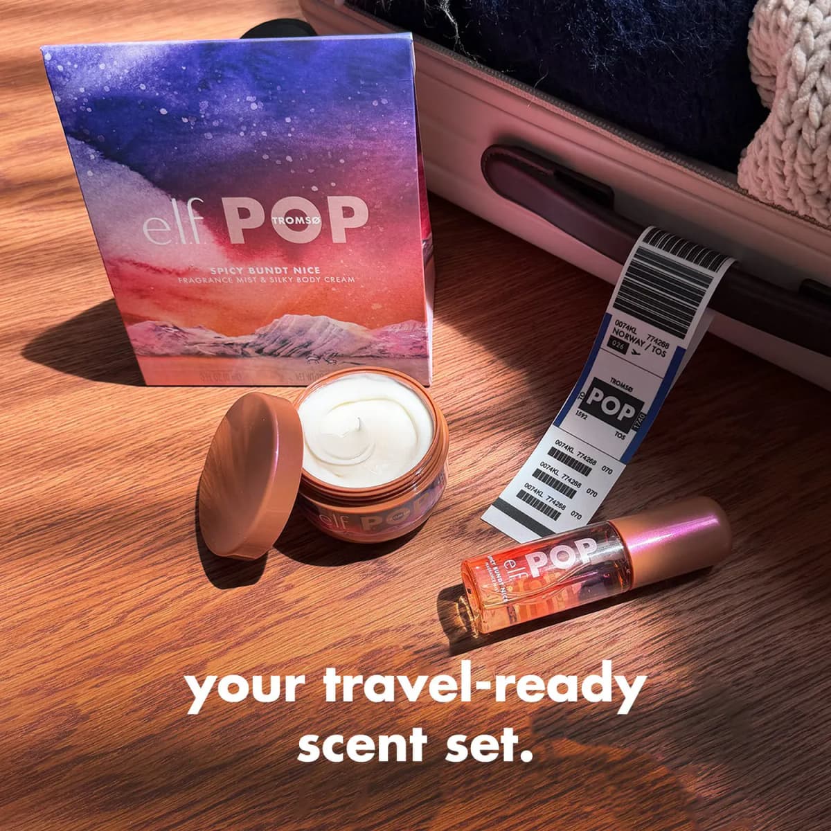Open mini cream jar, mini mist and watercolour e.l.f. POP box on wood floor by a suitcase with a Tromsø luggage tag.