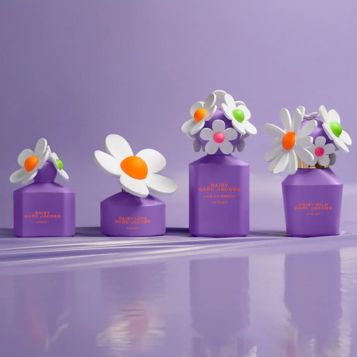 Marc Jacobs Daisy Violet Collection: four matte purple bottles with white daisy caps lined up on a reflective lilac surface