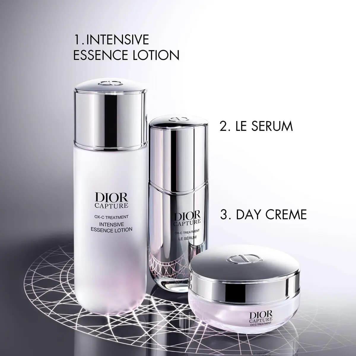 Three-step routine: Intensive Essence Lotion, Le Serum and Day Creme jar on a glowing patterned surface.