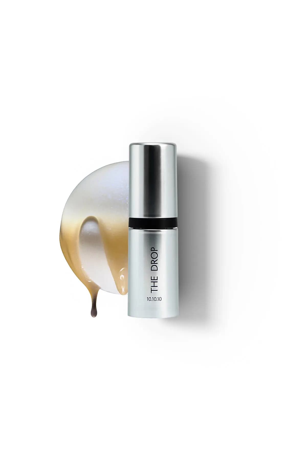 Single silver The Drop 10.10.10 ampoule beside a pearly white and gold dripping serum swatch on white