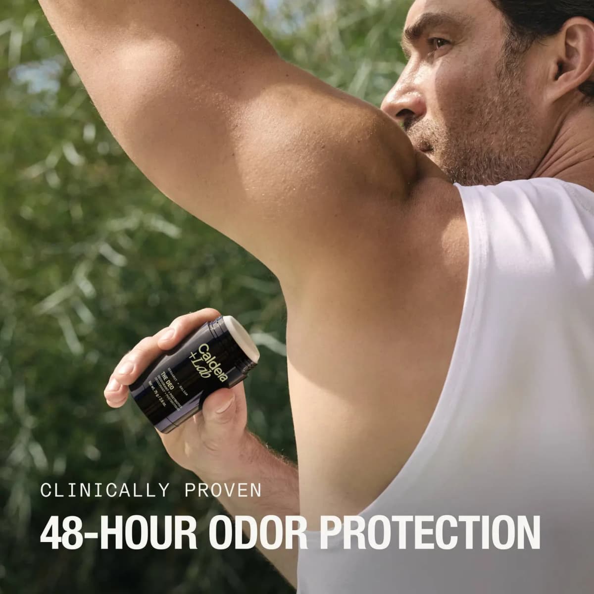 Man in white tank top raises his arm outdoors holding the open stick, captioned 48-hour odor protection