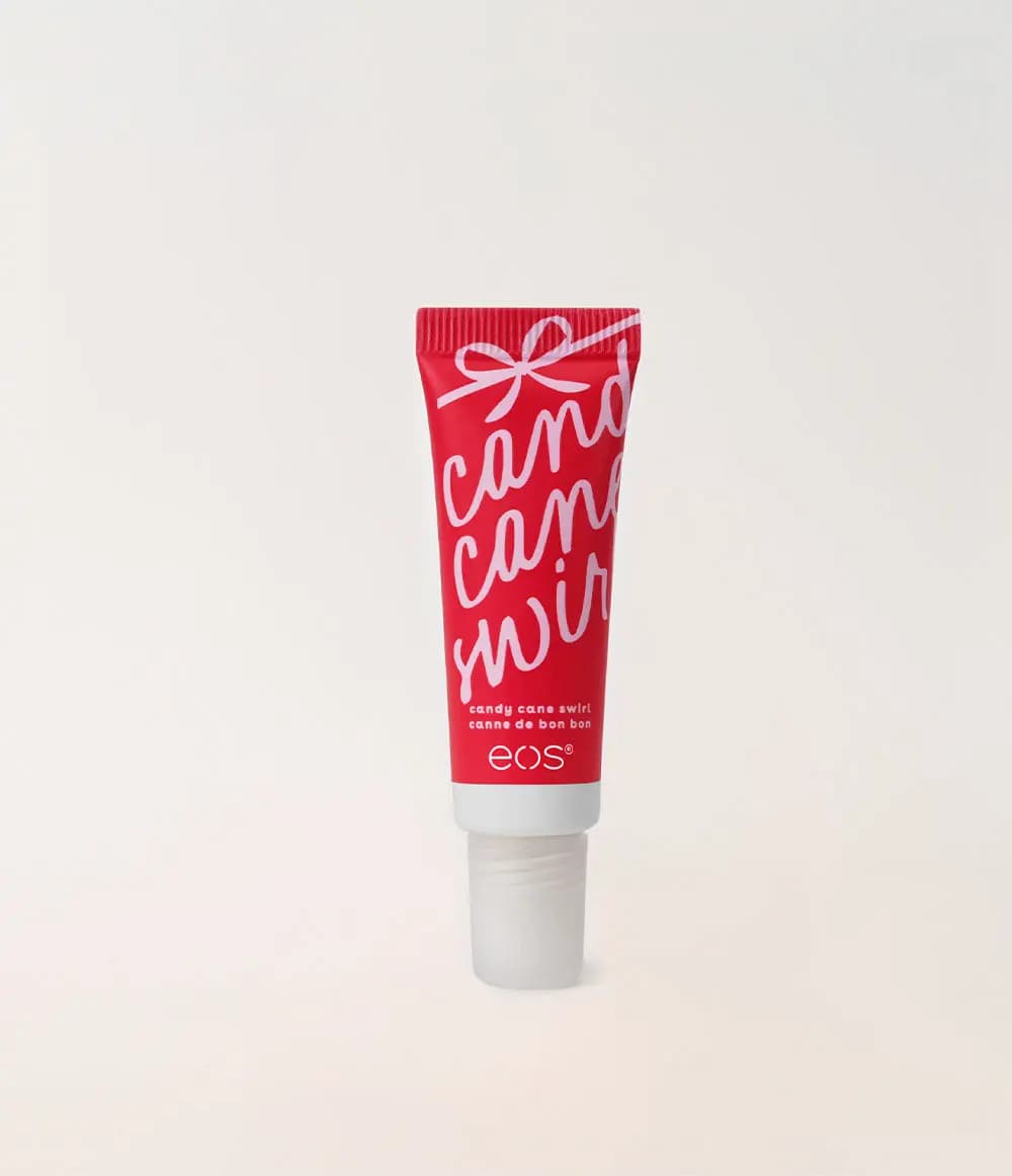 Red eos Candy Cane Swirl squeeze tube with pink script lettering and a frosted cap on a cream background