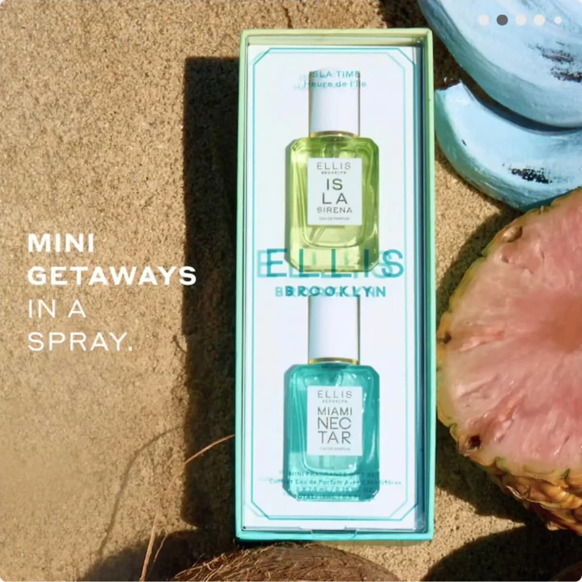 Open mint gift box holding both minis on sand next to a halved pink pineapple, with text "Mini getaways in a spray.