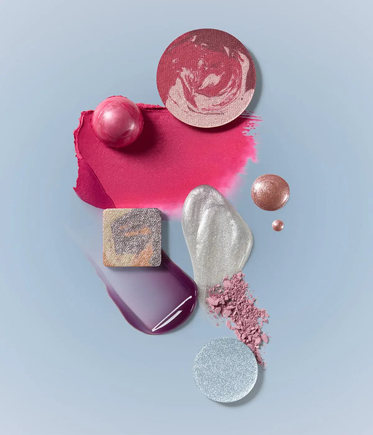 Swatches on blue: marbled blush, hot pink balm smear, silver and plum gloss, rose gold drops and crushed pink powder