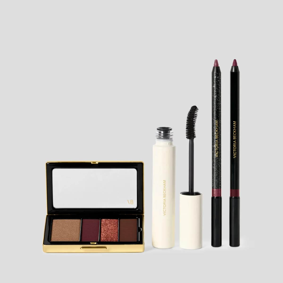 Bordeaux quad in bronze, plum, copper glitter and brown beside cream mascara and two burgundy-tipped liners