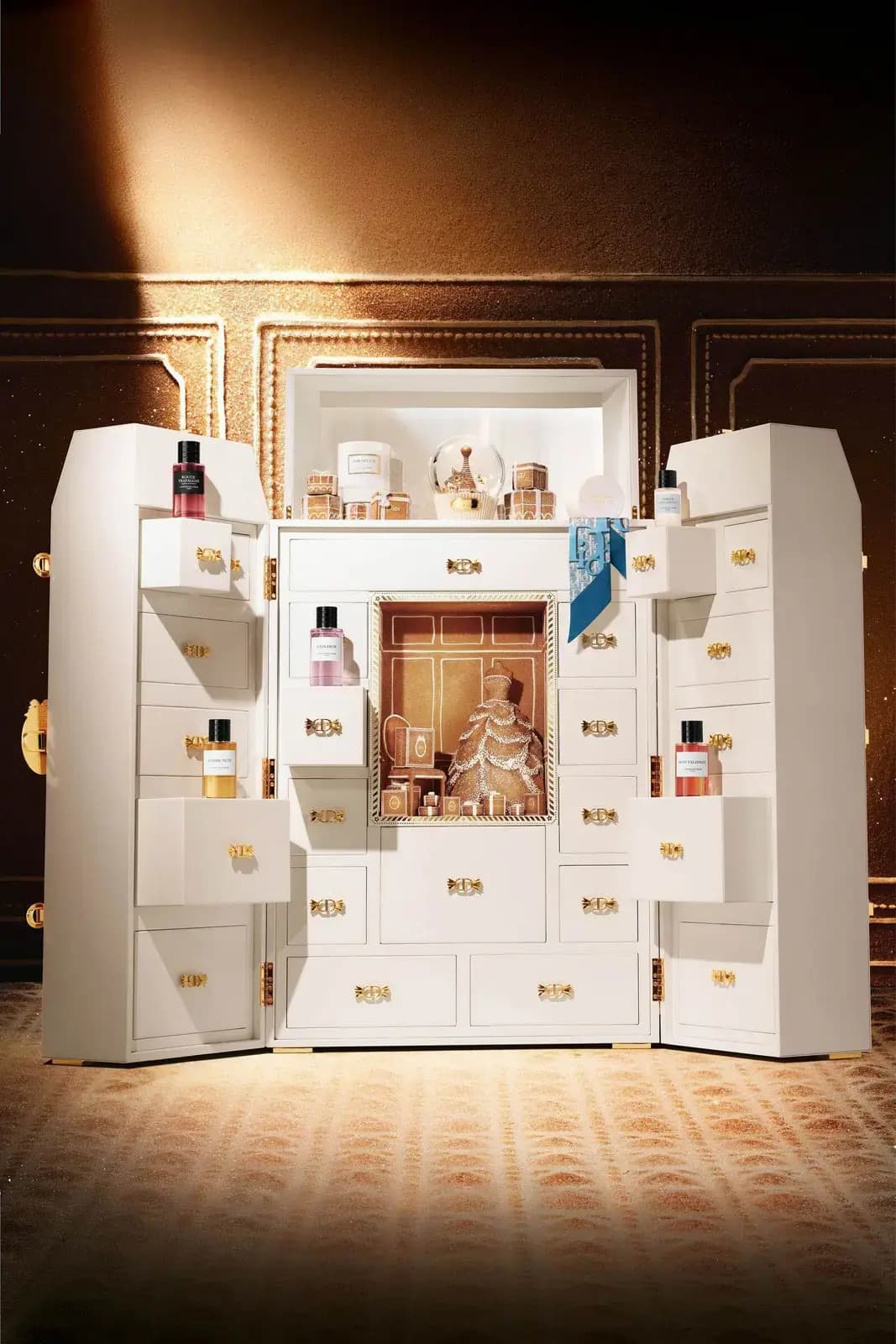 Dior La Malle des Rêves white lacquered trunk open to reveal gingerbread dollhouse scene with Junon gown replica