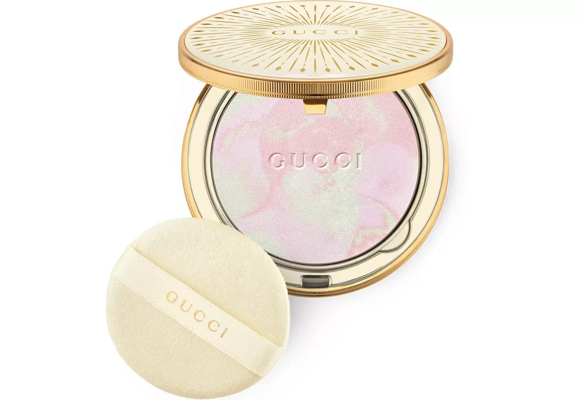 Open compact with pink and mint marbled powder shown alongside an ivory Gucci-branded powder puff