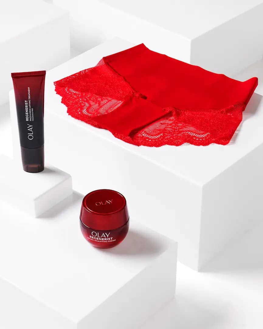 Red Spanx lace hi-hipster beside an OLAY Regenerist Face & Neck Lifting Treatment tube and Micro-Sculpting Cream jar