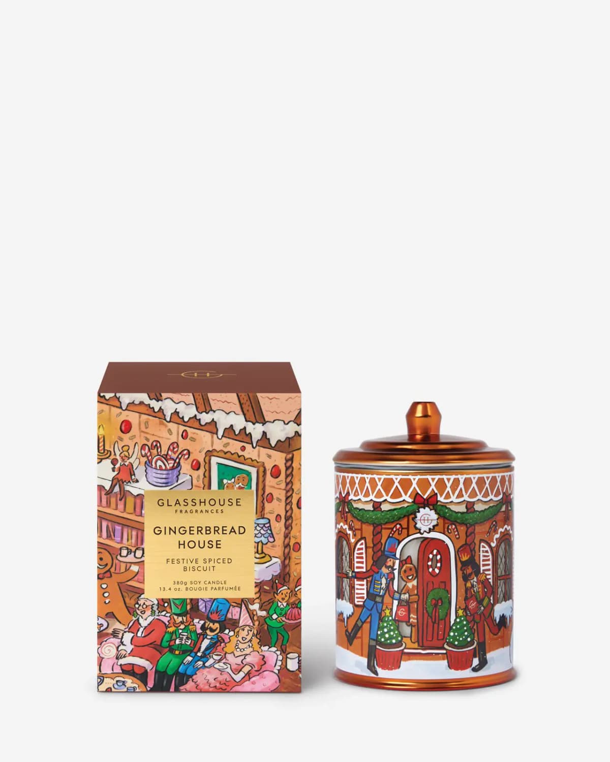 Gingerbread House candle with copper lid and nutcracker illustration next to its brown-topped box on a white background