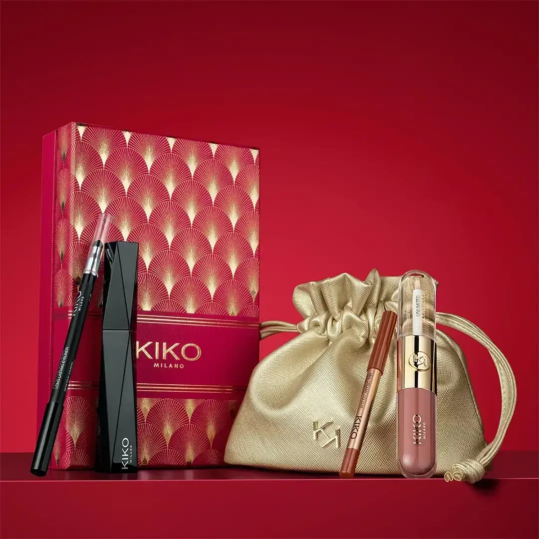 KIKO Milano red art-deco box with black eyeliner and mascara beside a gold pouch, lip liner and liquid lip colour