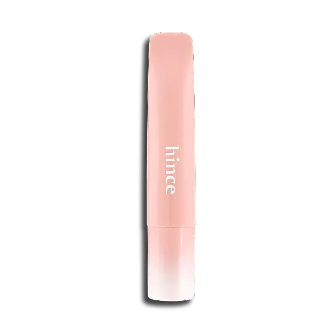 Pale peach-pink hince tube with white logo and soft gradient cap