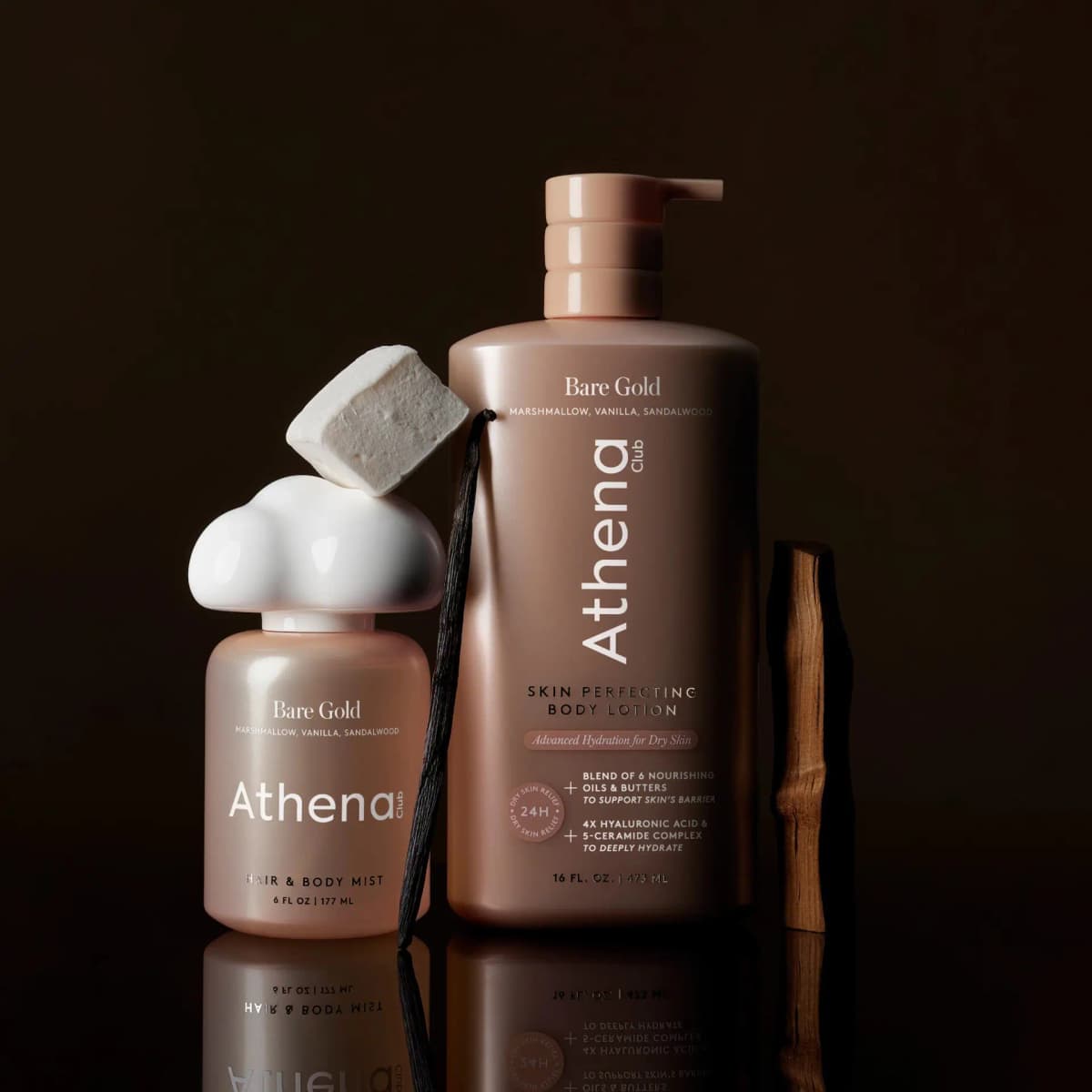 Mist and pump lotion on a dark backdrop, with a marshmallow on the cloud cap, a vanilla pod and a sandalwood stick