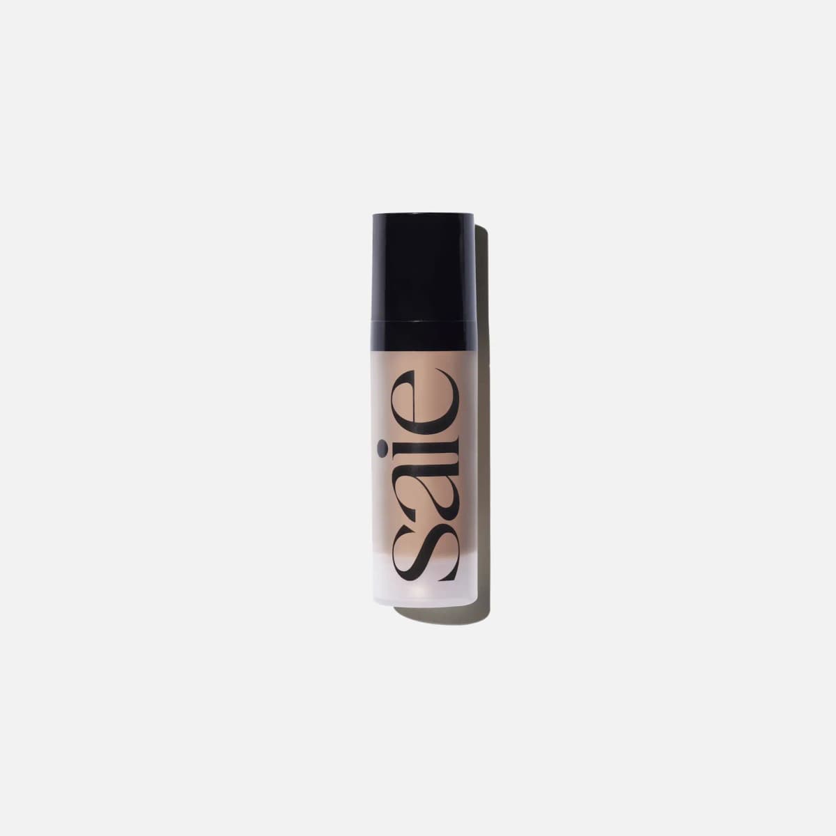 Frosted Saie bottle with black cap and vertical black logo, filled with a beige liquid, on a white background