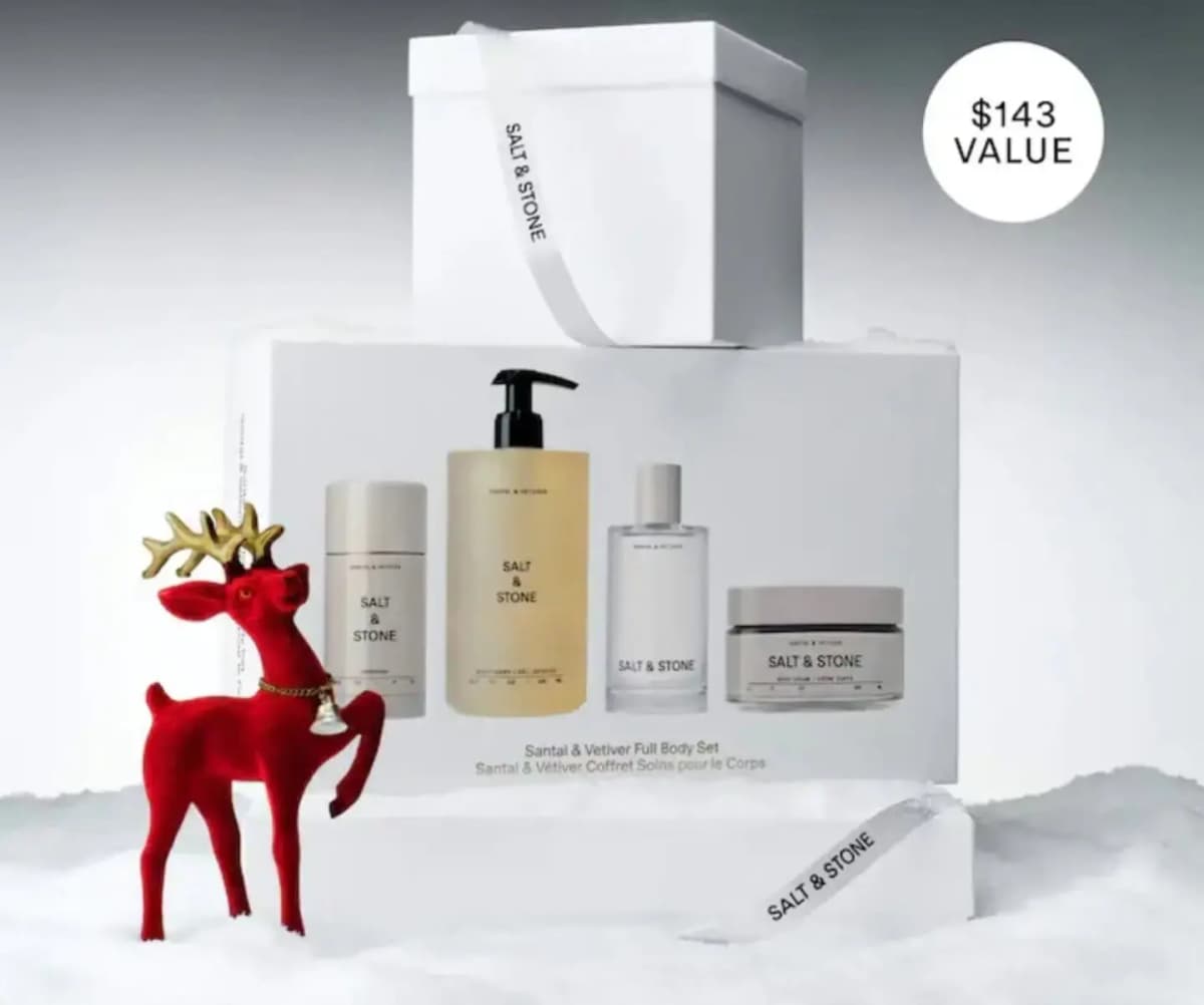 Gift set box on fake snow with a white ribbon box, red velvet reindeer figurine and a $143 value badge