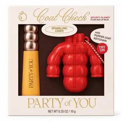 Party of You Coat Check Sparkling Cider set in a cream box with a yellow lip balm tube and red puffer coat keychain